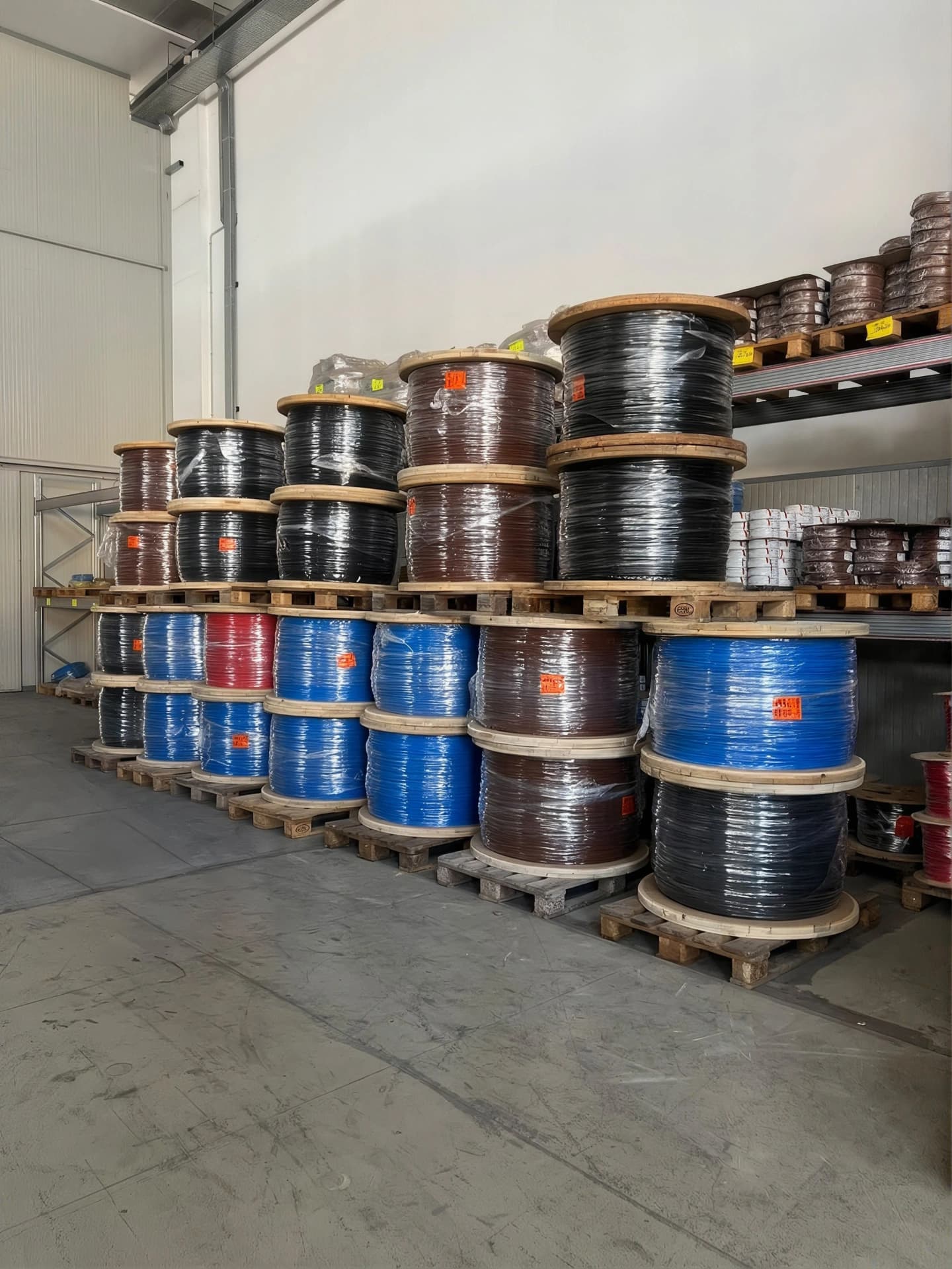 Bobine di cavo colorate su pallet in magazzino